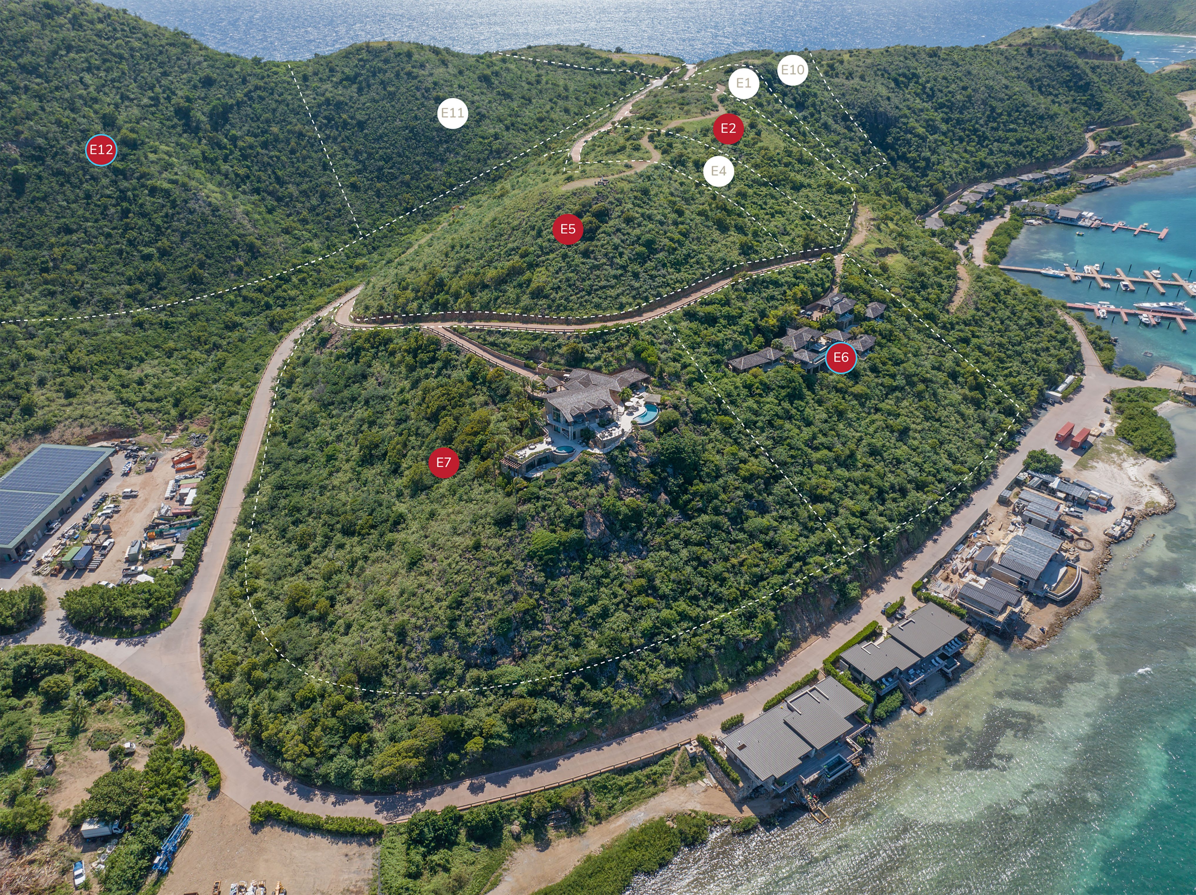 Aerial view of a hilly coastal landscape with a central luxurious villa, surrounded by lush greenery. A winding road ascends the hill, passing various labeled points (E1 to E12). At the base, modern waterfront housing developments are adjacent to a serene blue sea.