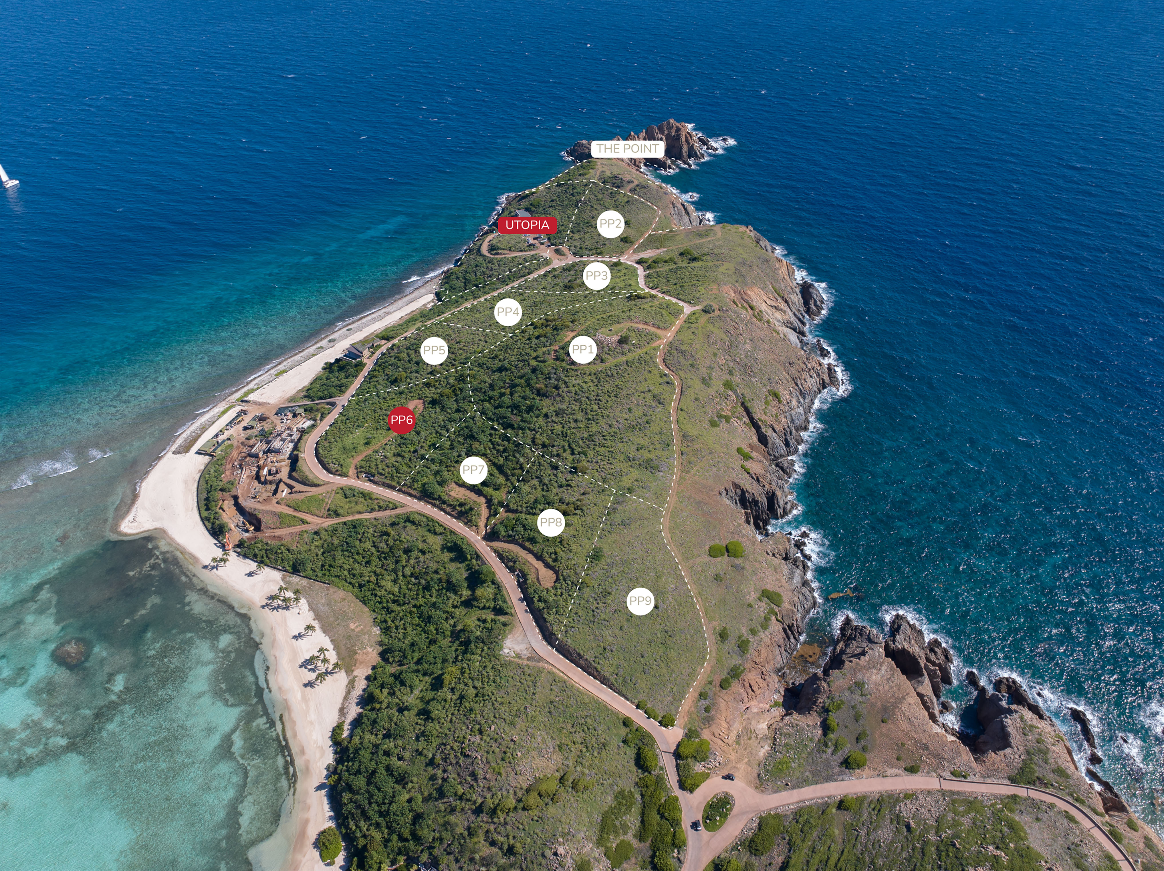 Aerial view of a picturesque coastal area featuring a rugged peninsula, known as Pajaros Point, surrounded by clear blue waters. The peninsula has scattered buildings labeled "The Point," "Utopia," "PP9," and other marked spots. Sandy beaches and lush greenery are visible.