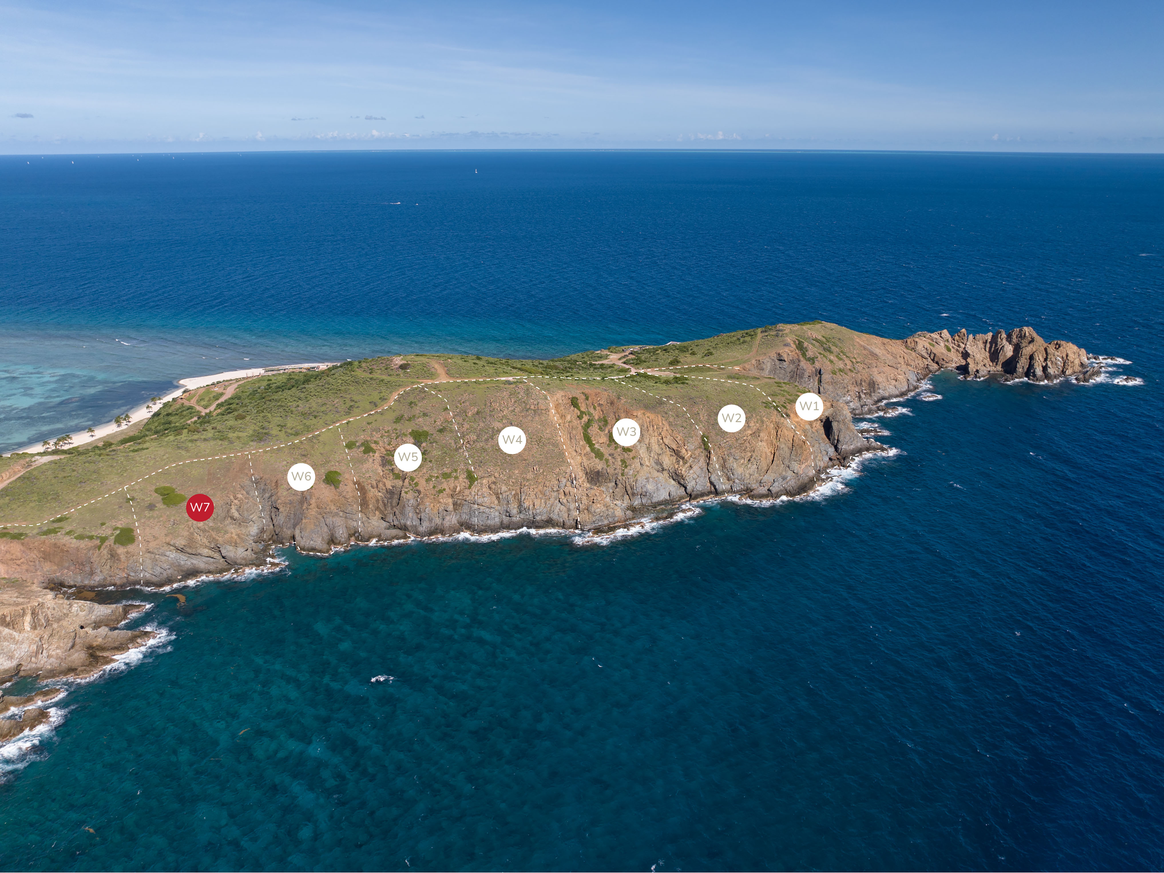 Aerial view of a rocky coastal area surrounded by blue ocean water. Several marked points labeled W1 through W7 are spread along the ridge of the Wildside peninsula. The sky is clear with scattered clouds visible on the horizon.