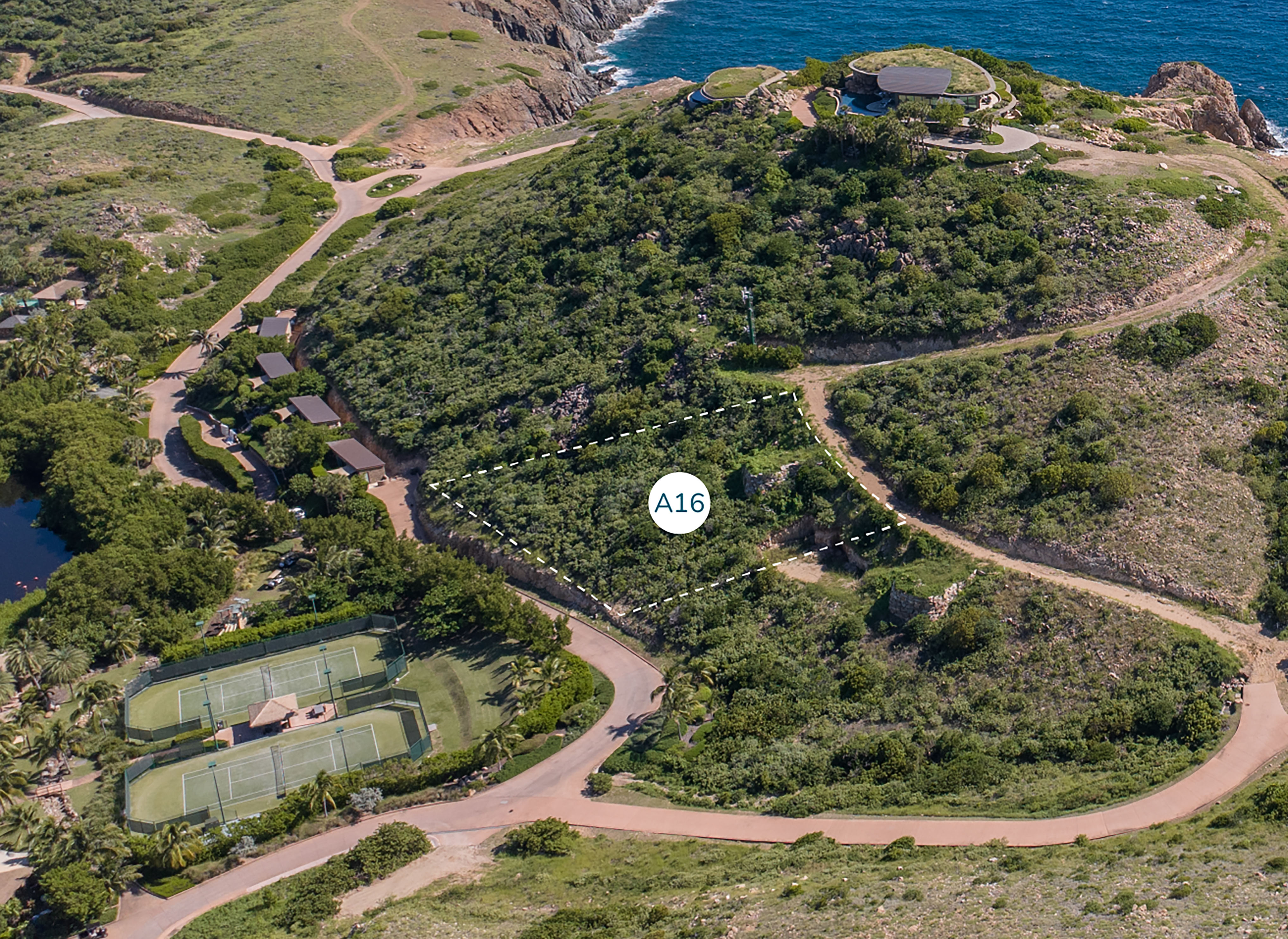 Aerial view of a hilly landscape near the Atlantic Ridge coastline, with dense greenery, winding roads, and scattered buildings. Homesite A16 is highlighted within the vegetation. Tennis courts and additional structures are visible in the lower part of the image.