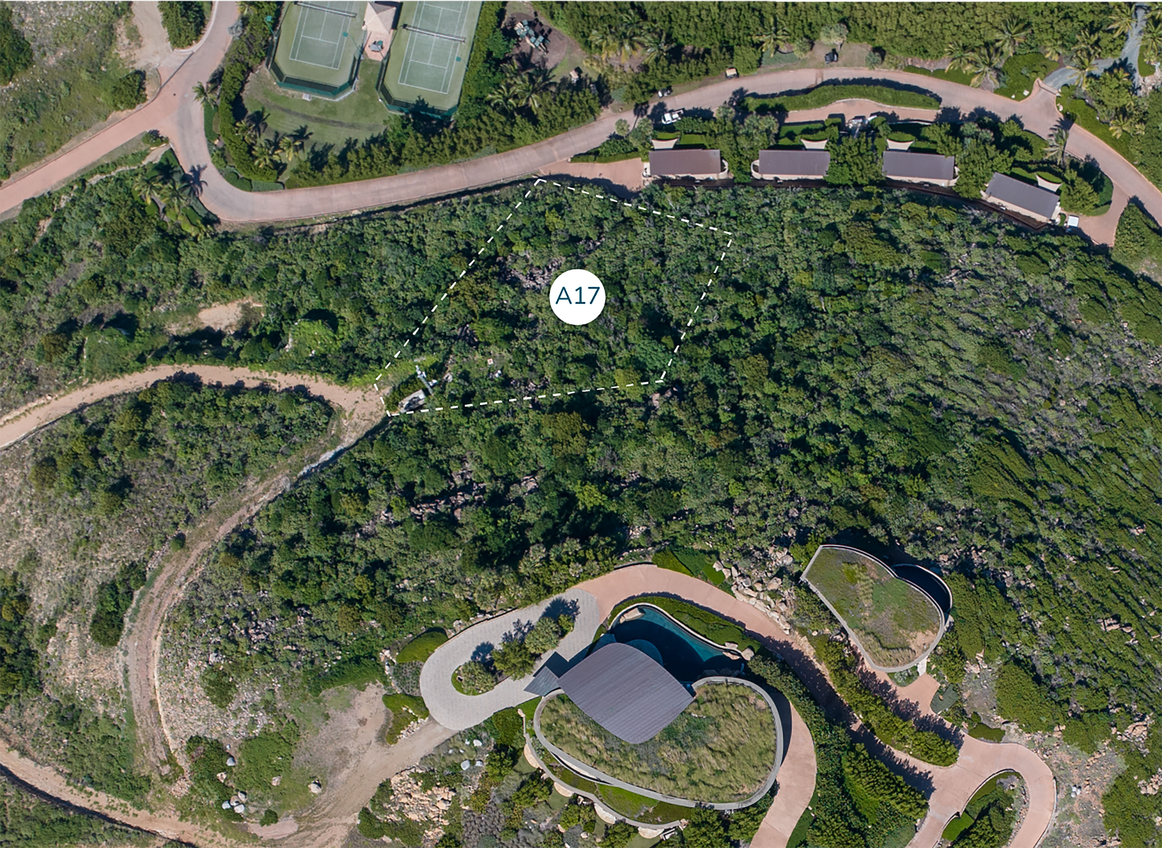 Aerial view of a lush green area with a circular white marker labeled 'A19' in the center. The landscape includes winding paths, residential houses, including ones from Atlantic Ridge Homesite, a unique building with curved architecture, and tennis courts in the upper left corner.